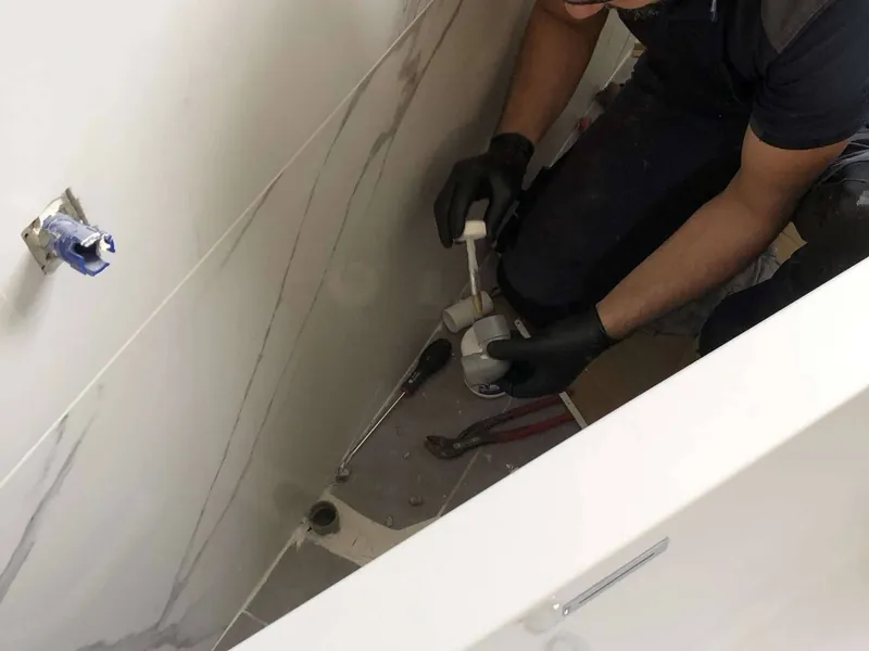 Plombier Chauffeo au travail sur un chantier de salle de bains