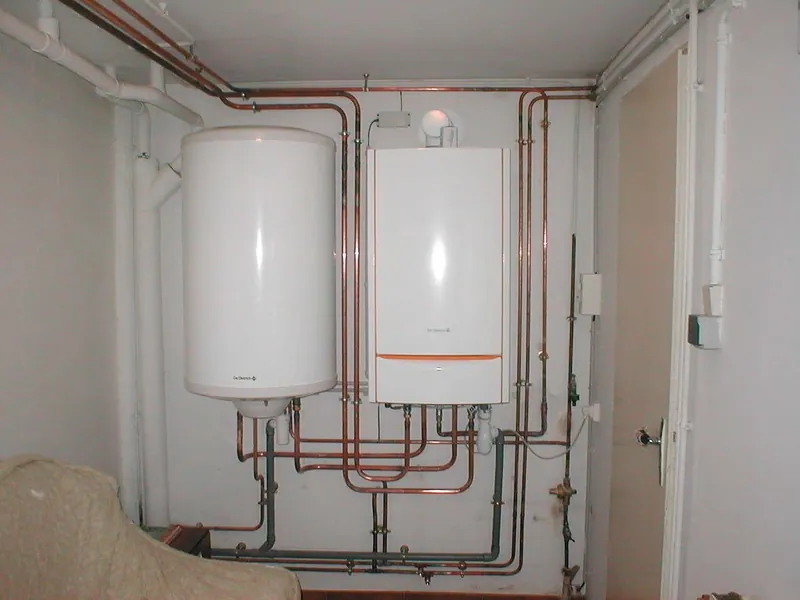 Chauffe-eau électrique et chaudière murale dans un local technique